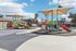 Inviting playground with vibrant slides and climbing structures, surrounded by sunny palm trees and picturesque sky.
