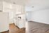 Bright and spacious apartment featuring a sleek white kitchen, modern appliances, and inviting open-concept living area with elegant wood flooring.