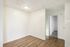 Bright room featuring fresh white walls, elegant wood flooring, and a cozy carpeted area leading to an adjacent space, ideal for creative interior design possibilities.
