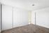 Bright and airy bedroom featuring a stylish sliding closet door and plush carpet flooring.