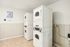 Bright and convenient laundry room featuring modern stacked washers and dryers, perfect for effortless living.
