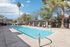 Inviting outdoor pool surrounded by lush greenery and stylish pergolas, offering a perfect relaxing retreat.
