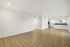 Bright and spacious open-concept living area with modern hardwood flooring and a sleek kitchen layout, perfect for entertaining.