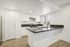 Modern kitchen with sleek white cabinetry, elegant gray countertops, and stainless steel appliances, perfect for culinary creativity and entertaining.