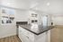 Modern open-concept kitchen with sleek countertops and natural light, adjacent to a bright living area with a cozy fireplace.