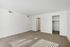 Bright and spacious bedroom with soft carpet flooring and ample natural light, featuring a walk-in closet and modern white walls.