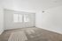 Bright and airy room with plush carpet and large windows, perfect for a relaxing bedroom setup.