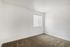 Bright and airy room with neutral walls and plush carpet, ideal for a cozy personal space.