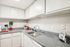 Bright and modern kitchen with sleek countertops, ample cabinetry, and inviting decor perfect for culinary enthusiasts.