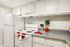 Charming kitchen with modern white cabinetry, sleek countertop, and cozy accents for a welcoming cooking space.