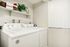 Bright laundry room with modern washer and dryer, stylish shelving, and ample natural light.