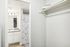 Modern bathroom with elegant butterfly-patterned shower curtain, sleek vanity, and spacious walk-in closet with shelving.