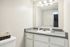 Modern bathroom showcasing a sleek countertop, large mirror, and elegant lighting for a fresh and inviting space.