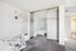 Bright bedroom with plush carpeting, mirrored closet doors, and modern decor creating a cozy and inviting space.