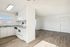 Bright and airy open-concept living space with modern kitchen and sleek hardwood flooring.