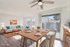 Bright and inviting living and dining area with elegant wooden furniture, large windows, and modern decor.