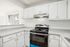 Modern kitchen with sleek white cabinets, stainless steel stove, and a spacious countertop, offering a bright, inviting atmosphere.