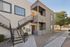 Charming two-story apartment exterior with modern design, featuring a welcoming balcony and convenient stair access.