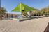 Inviting playground with vibrant slides under a green canopy, surrounded by charming community buildings and lush trees.