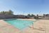 Inviting outdoor pool area with clear blue water, perfect for relaxation and leisure in a sunny setting.