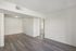 Bright and airy living space featuring elegant wood flooring and neutral walls, offering a spacious and open feel.