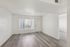 Bright and inviting living space with large window, sleek flooring, and modern minimalist design.