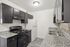 Chic kitchen with modern dark cabinets, granite countertops, and sleek appliances, creating a sophisticated cooking space.