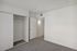 Bright bedroom with plush carpeting, sleek sliding closet doors, and modern white walls.