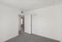 Inviting apartment bedroom with fresh white walls, cozy gray carpet, and natural light creating a serene atmosphere.