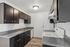 Chic and modern kitchen with sleek dark cabinets, elegant granite countertops, and contemporary appliances.