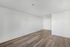 Bright, airy room with elegant wood flooring and a contemporary ceiling fan, perfect for modern living.