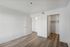 Inviting vacant room with elegant wooden flooring, bright white walls, and a spacious walk-in closet.