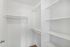 Bright and spacious walk-in closet with ample shelving and hanging rods, ideal for organizing your wardrobe efficiently.
