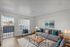 Bright and inviting living room with modern gray sofas, decorative cushions, and a cozy area rug, perfect for relaxation and entertainment.