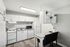 Contemporary kitchen with sleek white cabinets, modern appliances, and cozy dining nook.