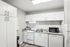 Modern kitchen with sleek white cabinetry, stylish appliances, and charming decor accents.
