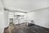Contemporary kitchen with sleek white cabinetry, integrated appliances, and chic wood flooring.