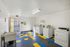 Bright and functional laundry room with colorful tiled floor, equipped with modern washers and dryers for convenient living.
