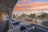 Charming apartment view showcasing vibrant sunset skies, palm trees, and ample parking space.