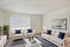 Bright and stylish living room with elegant white sofas, blue cushions, a lush plant, and a modern glass coffee table, exuding warmth and sophistication.