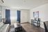 Bright and inviting living room with stylish gray sofa, sleek wooden flooring, and vibrant decor, perfect for relaxation and entertaining.