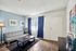 Bright and modern living room featuring a sleek gray sofa, elegant blue curtains, and vibrant artwork, providing a welcoming atmosphere.