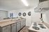 Modern kitchen with sleek countertops, contemporary cabinets, and stylish appliances, enhanced by decorative wall mirrors and vibrant decor for a welcoming atmosphere.