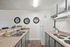 Modern kitchen with sleek countertops, dual sinks, and stylish mirrors, featuring contemporary cabinetry and a spacious fridge.
