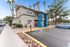Inviting leasing center with modern architecture, surrounded by lush palm trees and ample parking space.