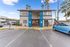 Inviting leasing center exterior with vibrant blue accents and palm trees, offering a welcoming atmosphere for prospective tenants.