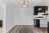 Contemporary apartment featuring a cozy kitchen with modern cabinetry, elegant flooring, and a stylish ceiling fan.