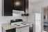 Modern kitchen with sleek dark cabinetry, electric stovetop, and spacious countertop, ideal for culinary enthusiasts.