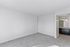 Bright and airy empty room with light gray carpet and sleek closet doors, adjacent to a modern bathroom with elegant lighting.