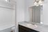 Elegant bathroom with a spacious sink area, updated lighting, and a pristine bathtub, offering a clean and modern ambiance.